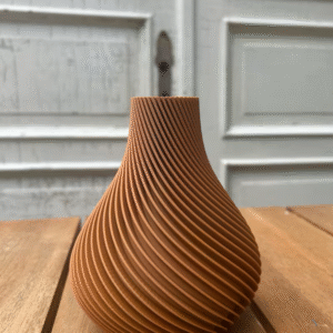 3D-gedruckte Vase in warmem Braunton mit eleganten, spiralförmigen Rillen vor einer rustikalen weißen Holztür.