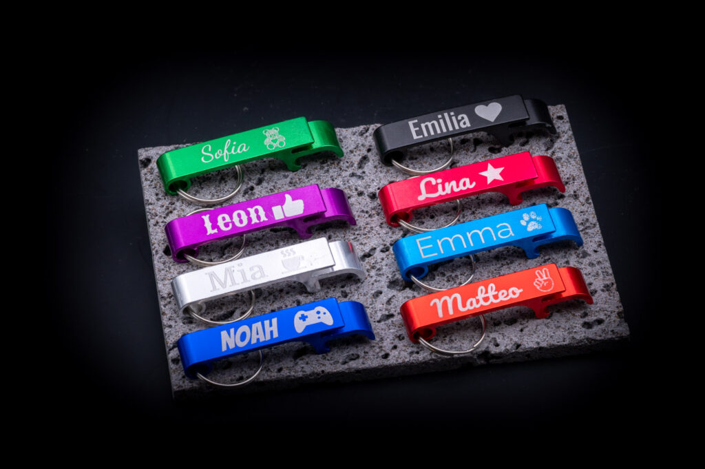 Personalisierte, farbenfrohe Flaschenöffner mit Namen auf stilvollem Hintergrund, ideal als Geschenk von MyDesignStyle.