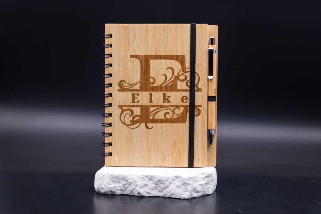 Hochwertiges Notizbuch aus Bambus mit personalisiertem Design, elegant gestaltet, inklusive Stifthalter und Stift.