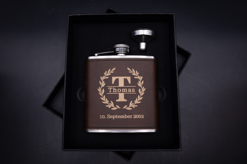 Personalisierter, gravierter Flachmann aus Edelstahl mit braunem Lederbezug, elegantes Geschenk in schwarzer Präsentbox.