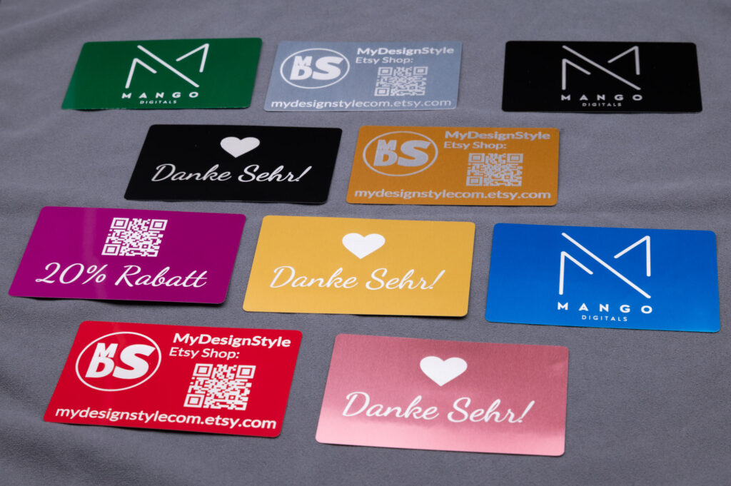 Verschiedene farbenfrohe, glänzende Visitenkarten von MyDesignStyle, stilvoll auf grauem Hintergrund arrangiert.