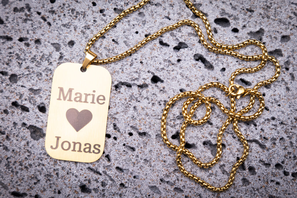 Goldene Halskette mit Gravur Marie ♥ Jonas auf einzigartigem 3D-gedrucktem Stein als perfektes Liebesgeschenk.